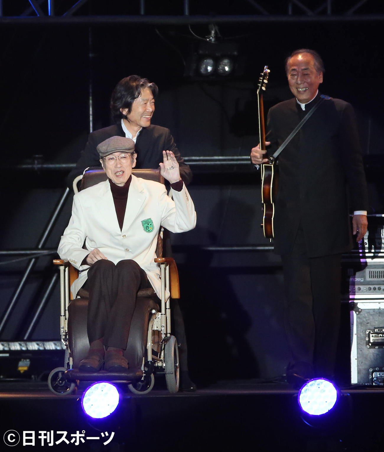 ザ・タイガース復活ツアー最終公演で手を上げて舞台から引き揚げる岸部四郎さん。後ろは瞳みのる、右は岸部一徳（2013年12月27日撮影）