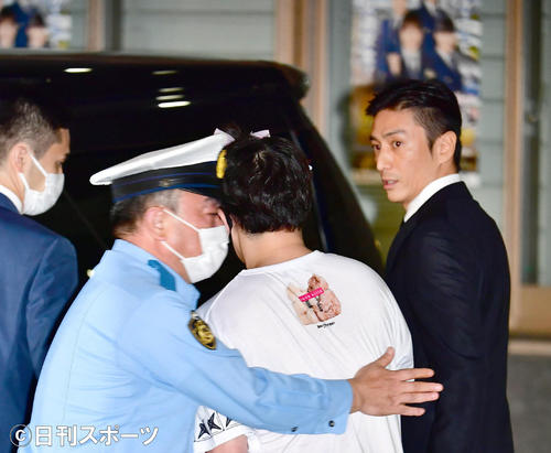 大麻取締法違反の罪で起訴され、この日東京湾岸署から保釈された俳優の伊勢谷友介被告（右）に男性が直撃を試みて警察署員に取り押さえられるハプニングが起こった（撮影・小沢裕）