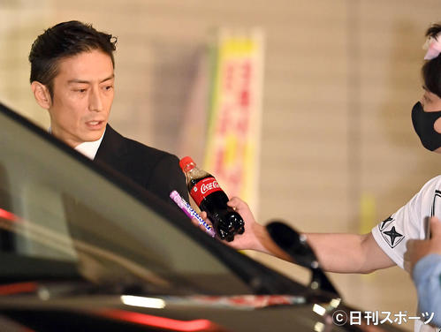 保釈され車に乗り込む伊勢谷友介被告は、乱入者に飲料水とお菓子を差し出される（撮影・たえ見朱実）