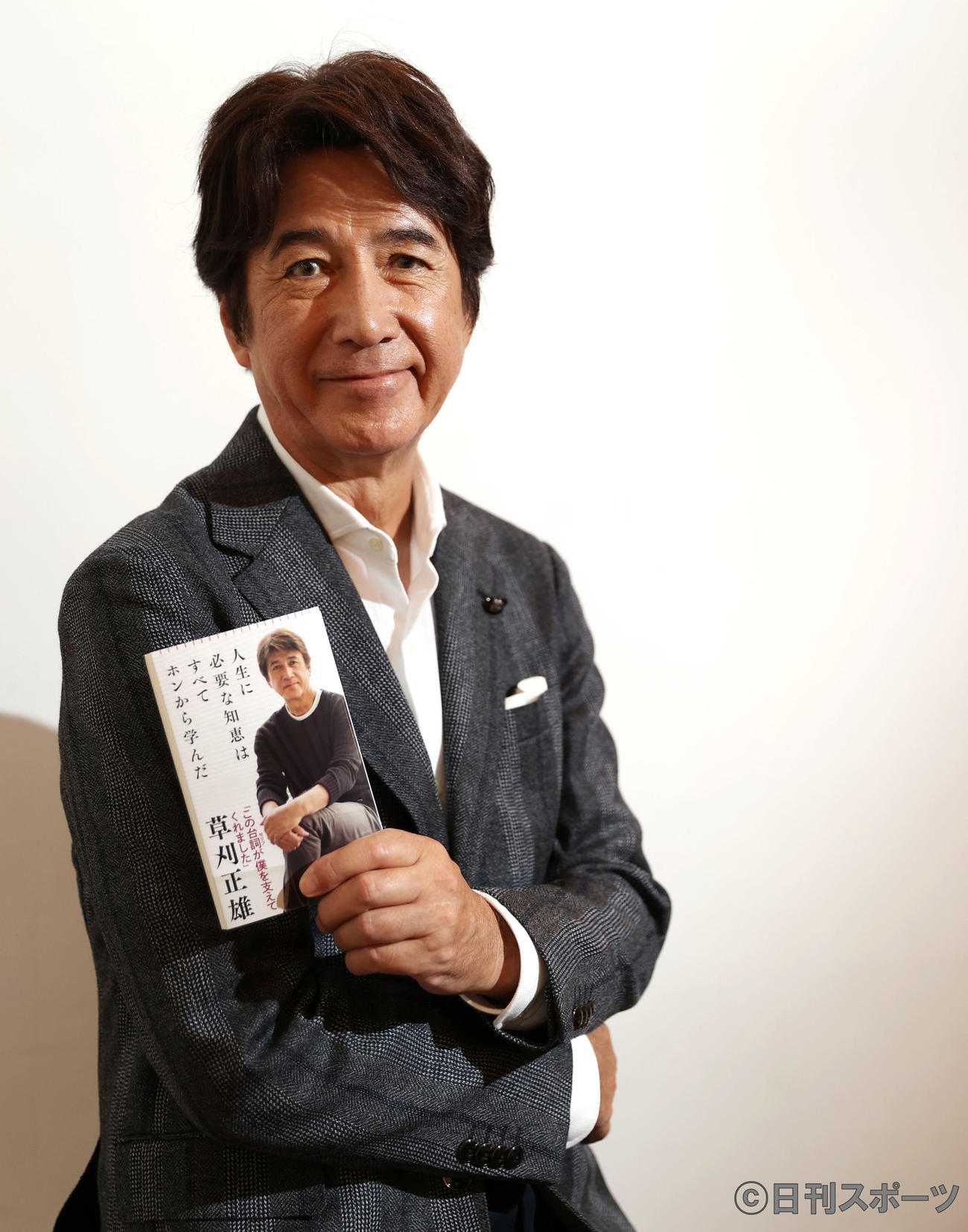 自身の著書を手にダンディーな草刈正雄（撮影・垰建太）
