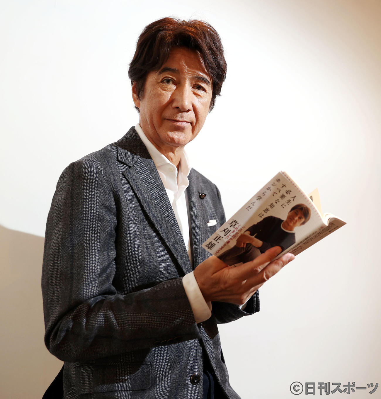 自身の著書を手にダンディーな草刈正雄（撮影・垰建太）