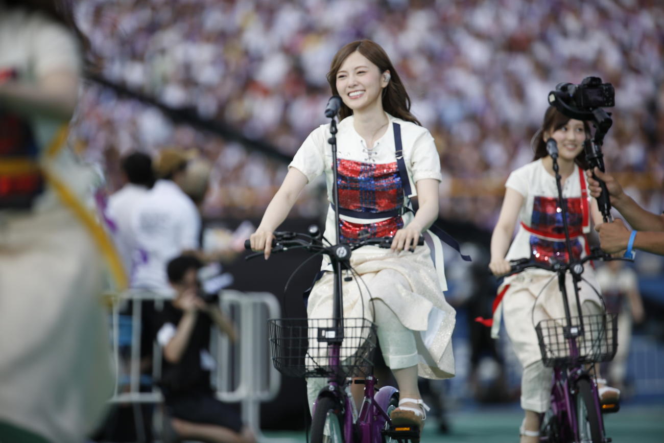 18年7月、「走れ！Bicycle」で自転車に乗って神宮球場に登場する白石麻衣