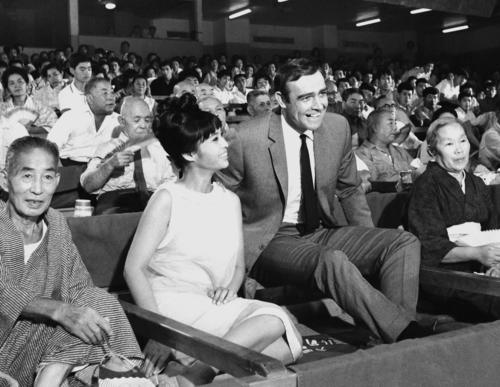 66年9月、スパイ映画「007は二度死ぬ」の撮影で、東京・蔵前国技館の桟敷席に座るショーン・コネリーさん（中央右）とボンドガールの若林映子さん（同左）（共同）