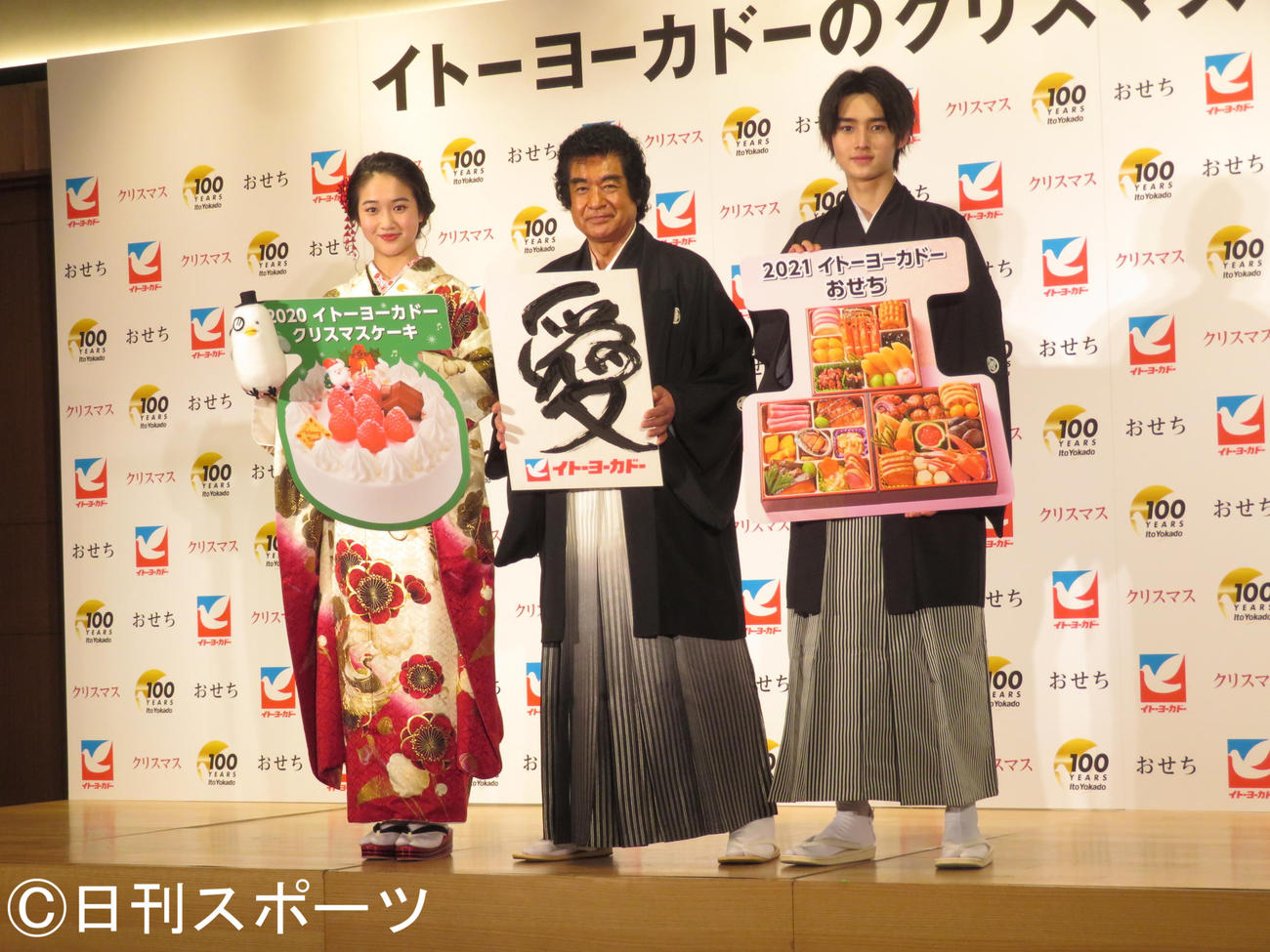「愛」と書いたボードを持って笑顔を見せる藤岡弘、。左は天翔愛、右は藤岡真威人（撮影・横山慧）