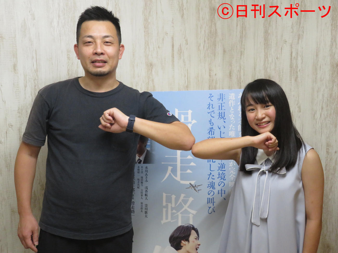 大庭功睦監督（左）とひじタッチで撮影に応じる木下渓