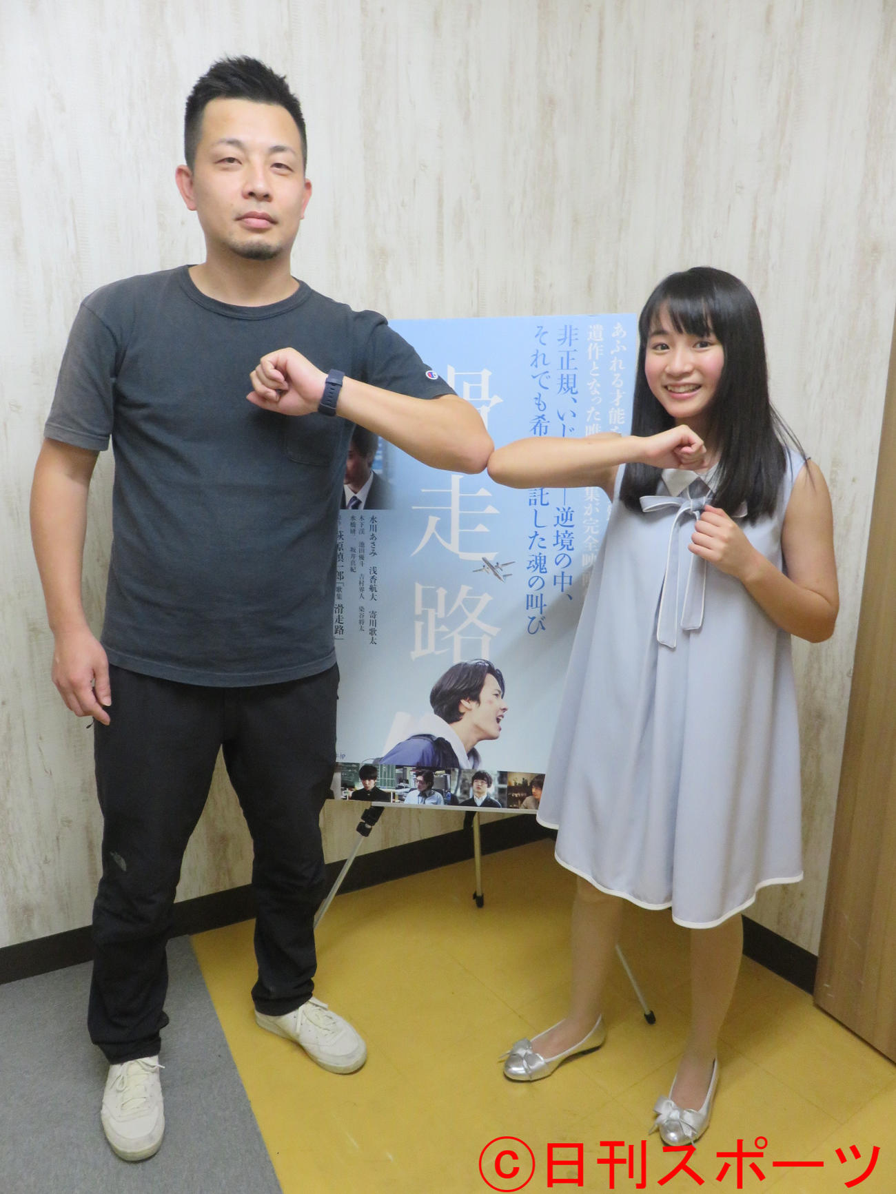大庭功睦監督（左）とひじタッチで撮影に応じる木下渓