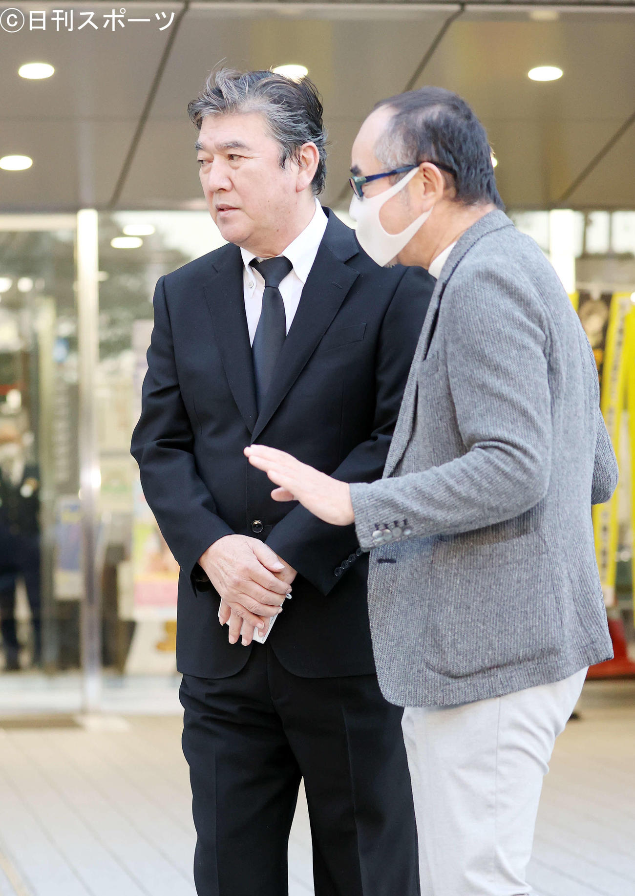 関係者（右）にうながされ車に向かう小金沢昇司容疑者（撮影・鈴木正人）