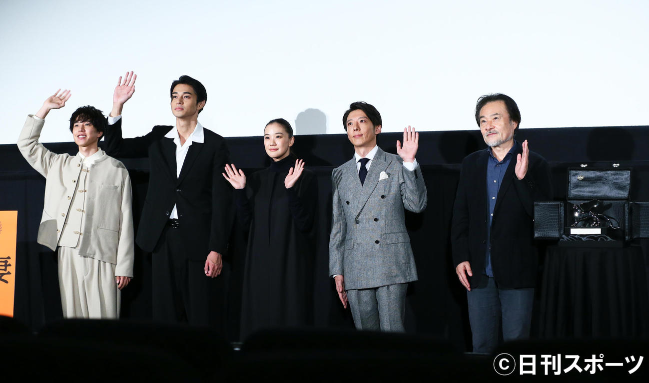 ベネチア映画祭の銀獅子トロフィーを披露し、笑顔で手を振る映画「スパイの妻」の、左から板東龍汰、東出昌大、蒼井優、高橋一生、黒沢清監督（2020年10月17日撮影）