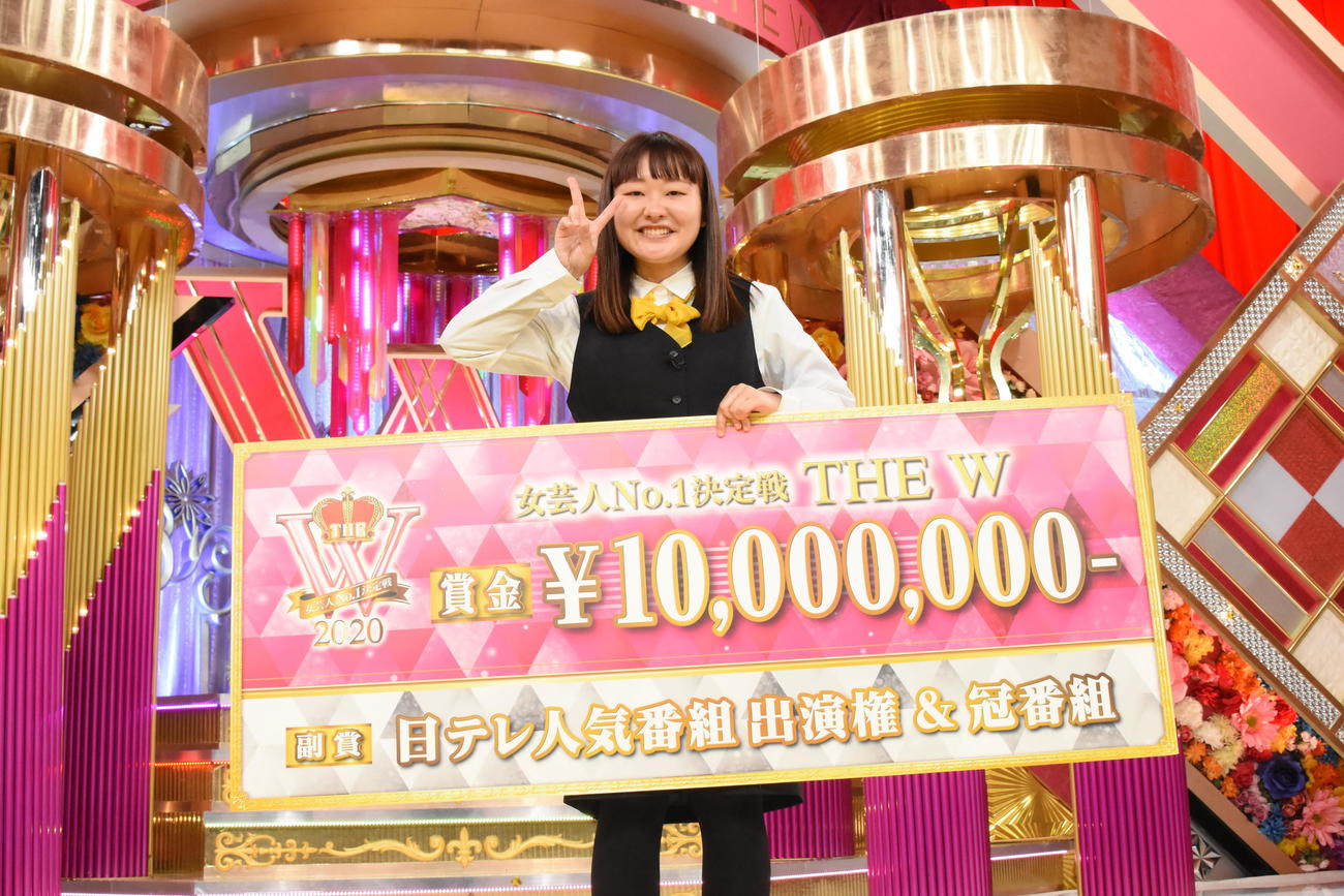 第4回女王に輝き、賞金のボードを掲げる吉住