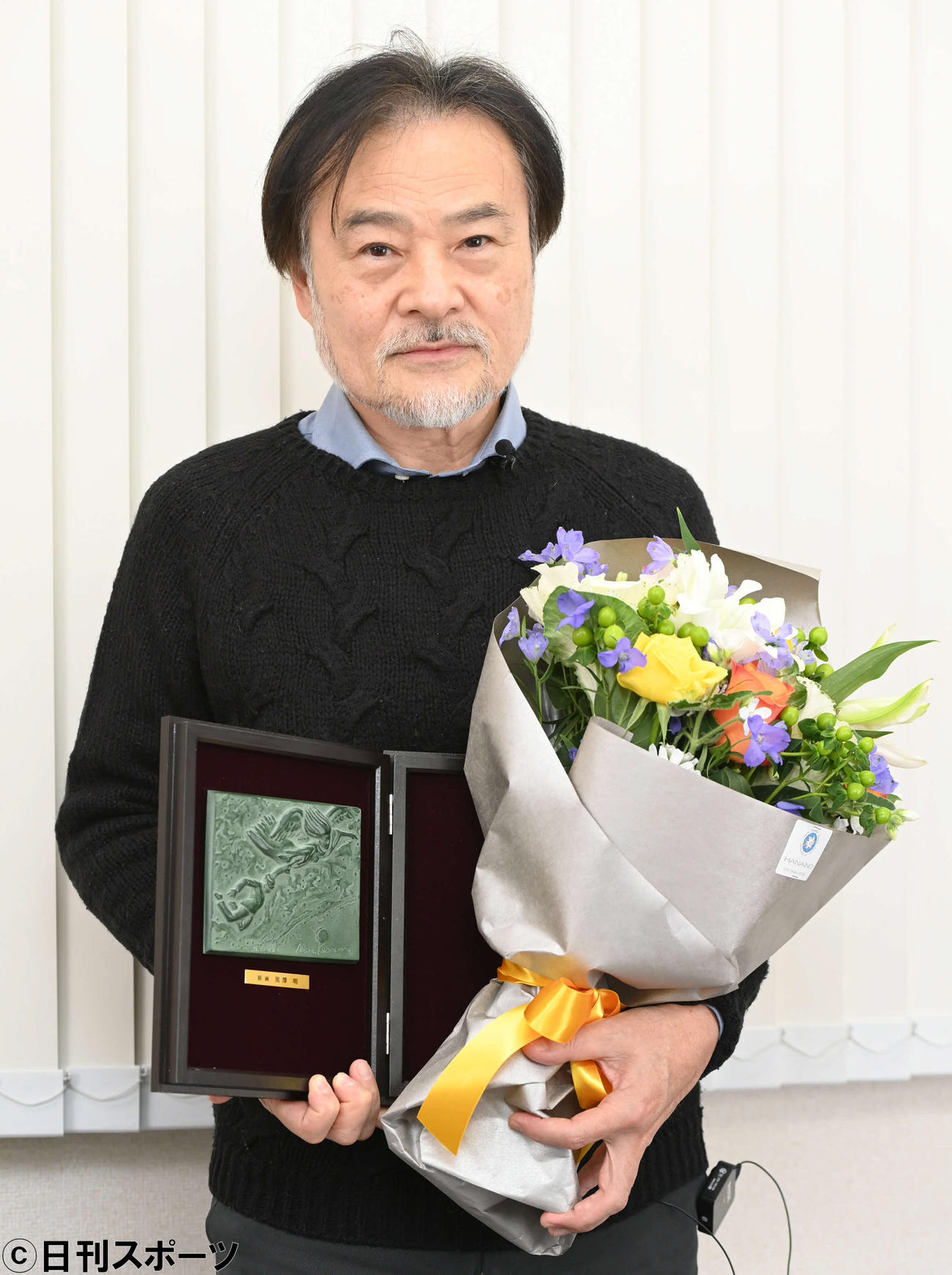 監督賞の記念盾と花束を手にする黒沢清監督（撮影・山崎安昭）
