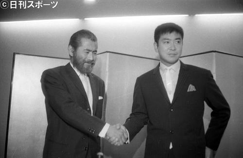 がっちり手を握り合って共同製作の実現を喜び合う三船敏郎さん(左)と石原裕次郎さん(1964年10月1日撮影)