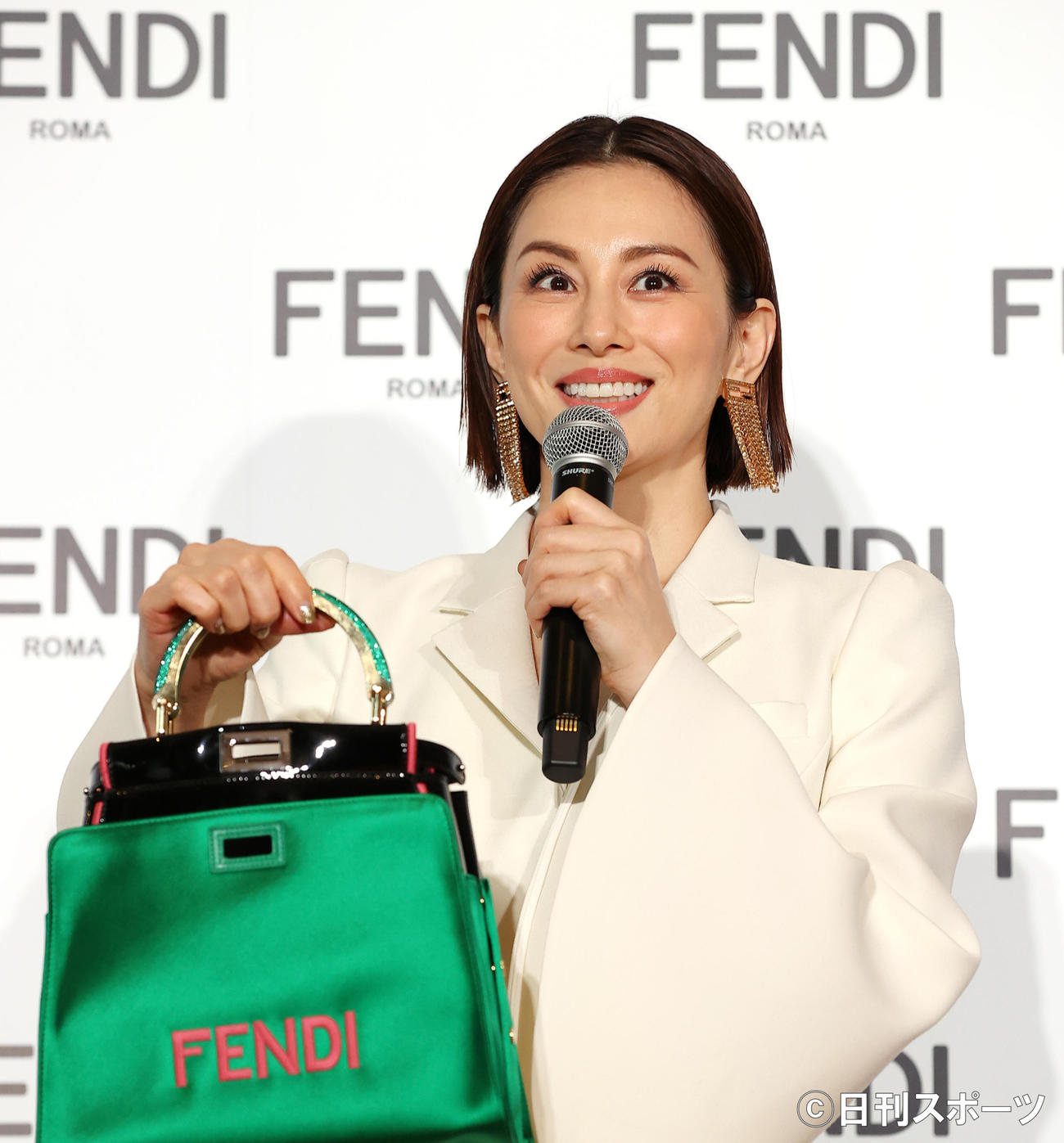 「FENDIジャパンブランドアンバサダー」に就任した米倉涼子は緑のバックを手に笑顔を見せる（撮影・浅見桂子）