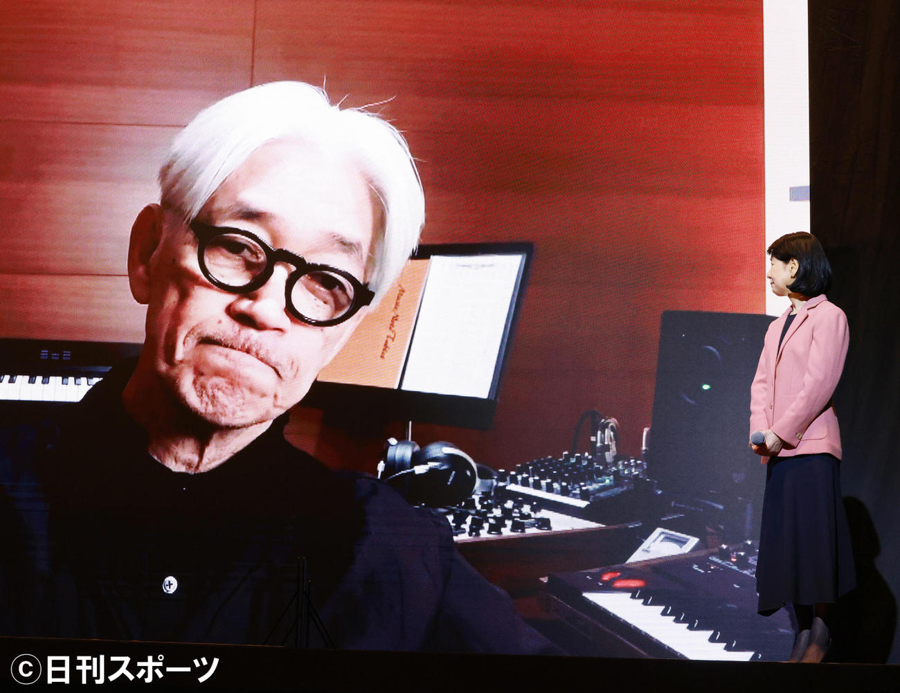 「UICCワールドキャンサーデー2021 Light up the world I AM AND I WILL－未来にひかりをつなぐライトアップ点灯式」で流された坂本龍一のビデオメッセージ。右は吉永小百合（撮影・中島郁夫）