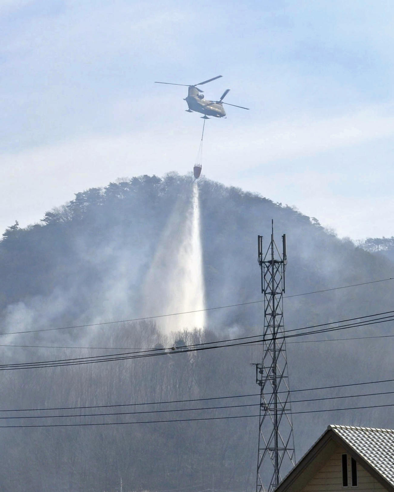 栃木県足利市の山火事現場で放水するヘリコプター（共同）