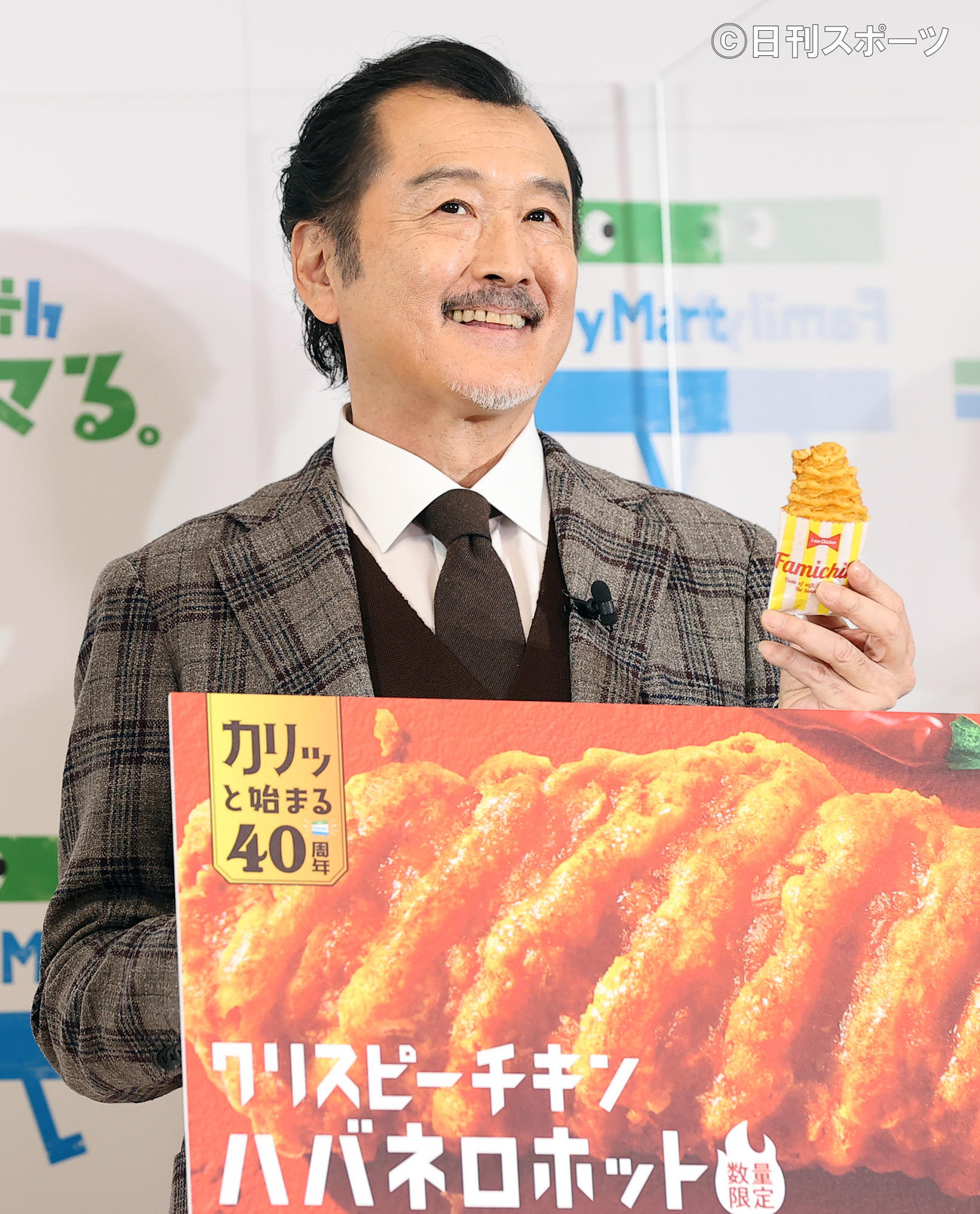 ファミリーマート創立40周年記念発表会で、新商品のクリスピーチキンを手に笑顔を見せる吉田鋼太郎（撮影・浅見桂子）
