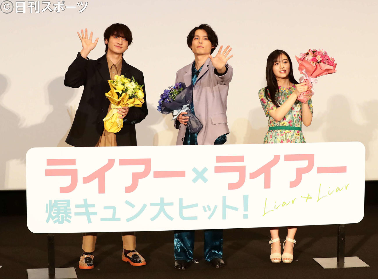 映画「ライアー×ライアー」の舞台あいさつで、客席に向かって手を振る、左から小関裕太、松村北斗、森七菜（撮影・丹羽敏通）