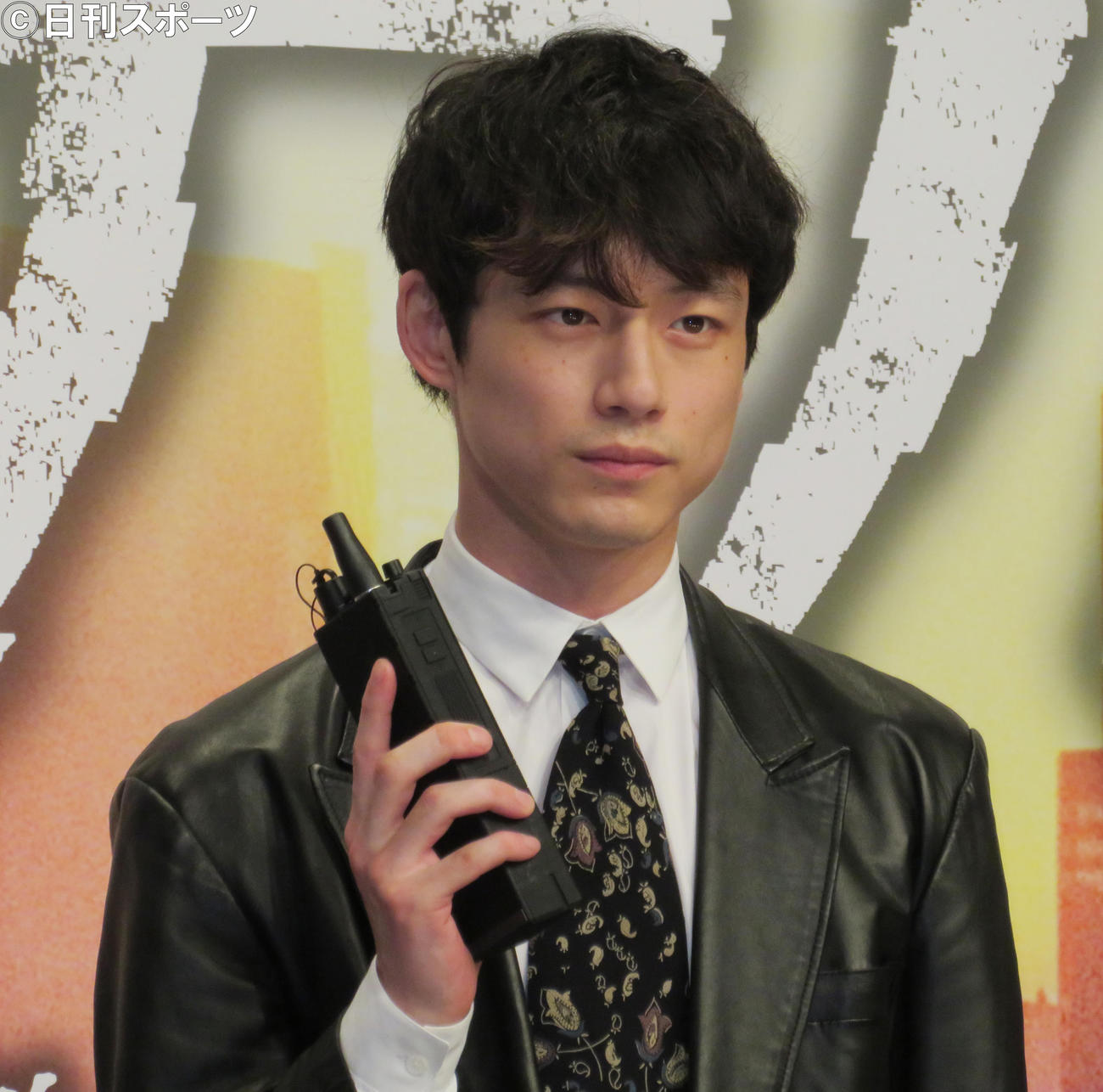 完成報告会に出席した坂口健太郎はトランシーバーを手にポーズをとる（撮影・佐藤勝亮）