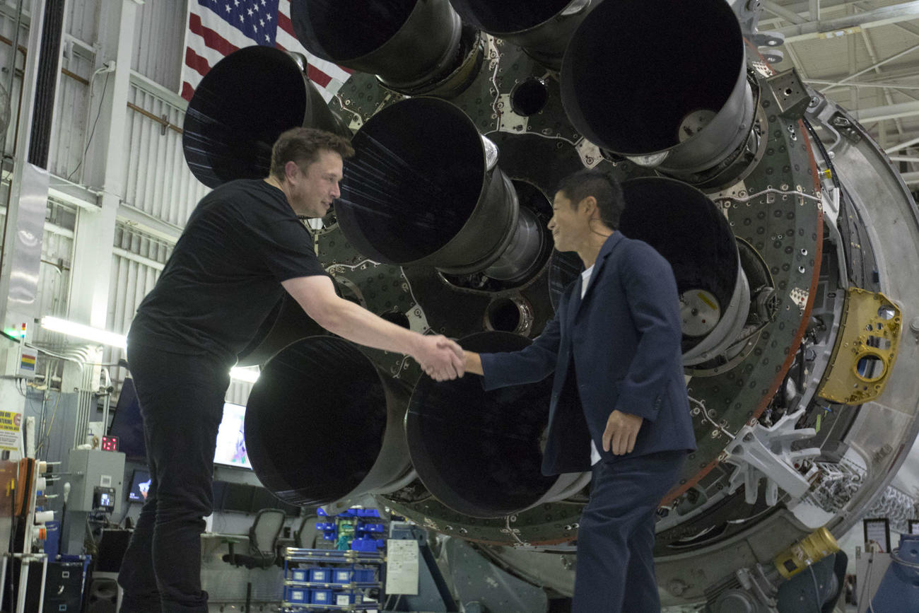 18年9月17日に米ロサンゼルスで会見を開いた際、握手する前澤友作氏（右）とイーロン・マスク氏