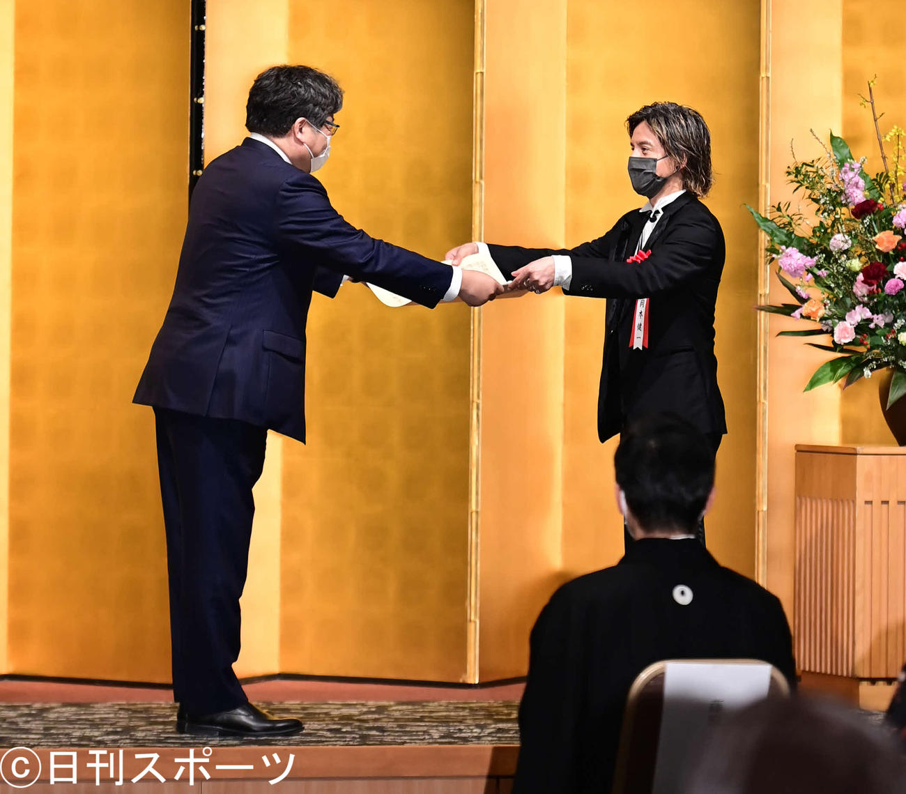 令和2年度芸術選奨演劇部門の大臣賞を受賞し、贈呈式で萩生田文科相（左）から表彰状を授与される岡本健一（撮影・小沢裕）
