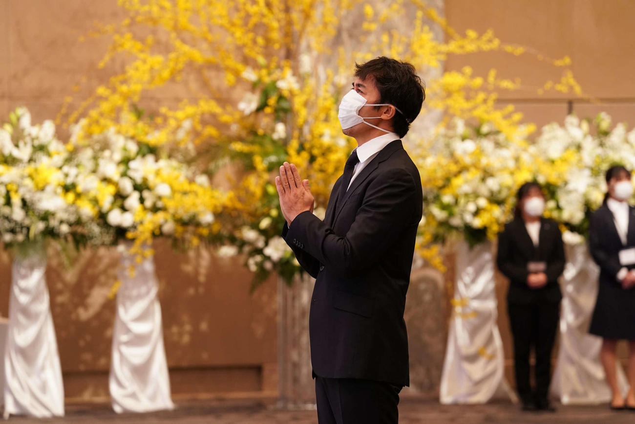 岡田裕介会長の祭壇に手を合わせる阿部寛（東映提供）