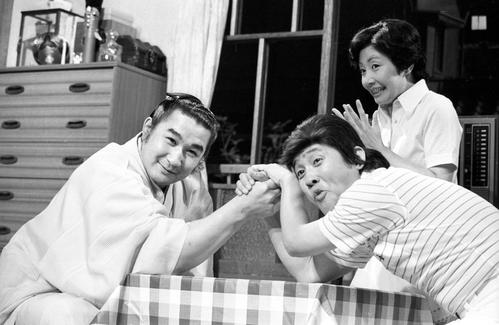 78年6月、テレビ朝日「欽ちゃんのどこまでやるの！？」に出演した貴ノ花（左）と萩本欽一の腕相撲を見つめる真屋順子さん