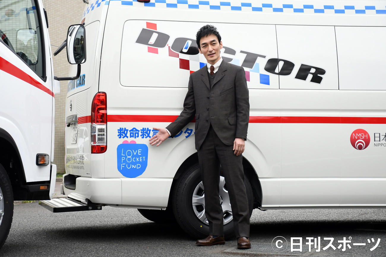 ドクターカーについている「LOVE POCKET FUND」のマークを指す草なぎ剛（撮影・大友陽平）
