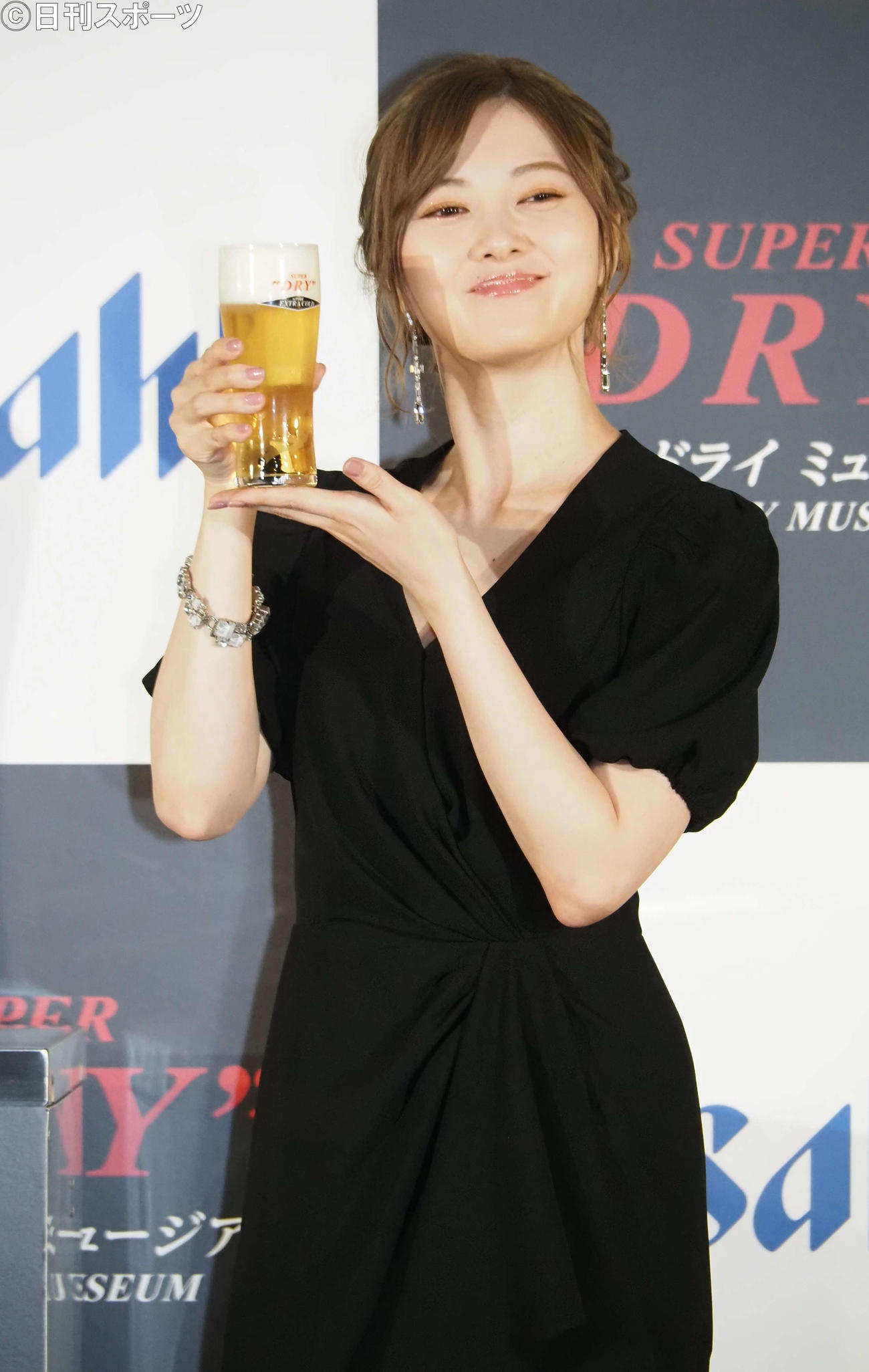 ビールを一口飲んで笑顔を見せる白石麻衣（撮影・遠藤尚子）