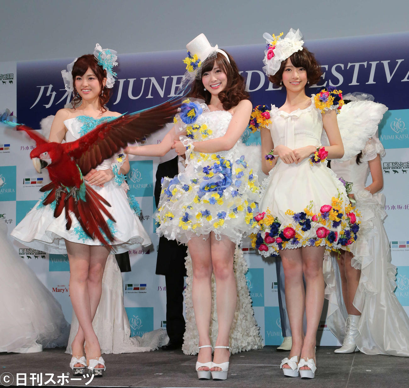 那須どうぶつ王国のインコ「モリー」と写真に納まる、左から乃木坂46の松村沙友理、白石麻衣、橋本奈々未（2014年6月22日撮影）
