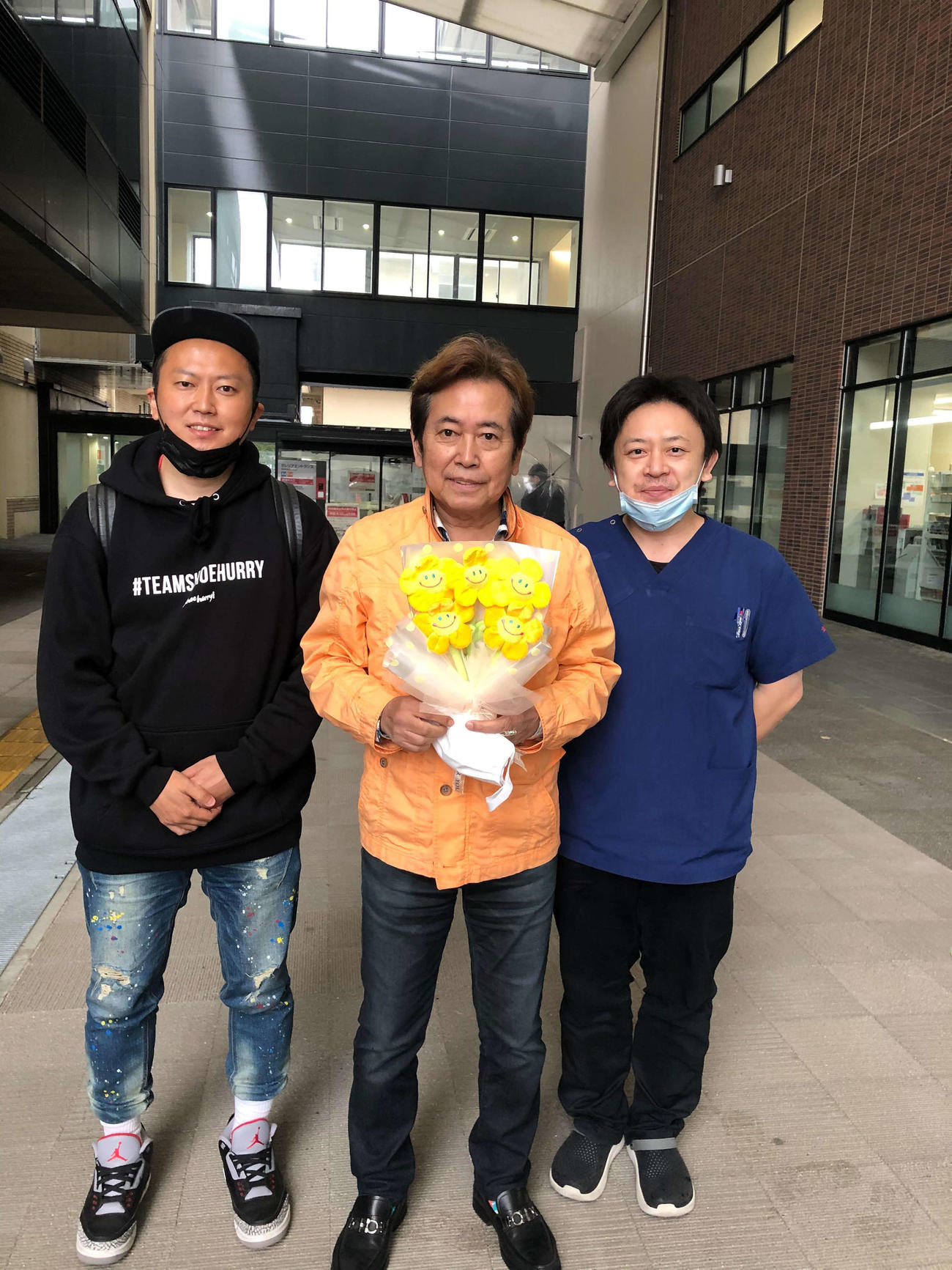 くも膜下出血から回復し、退院した平浩二（真ん中）