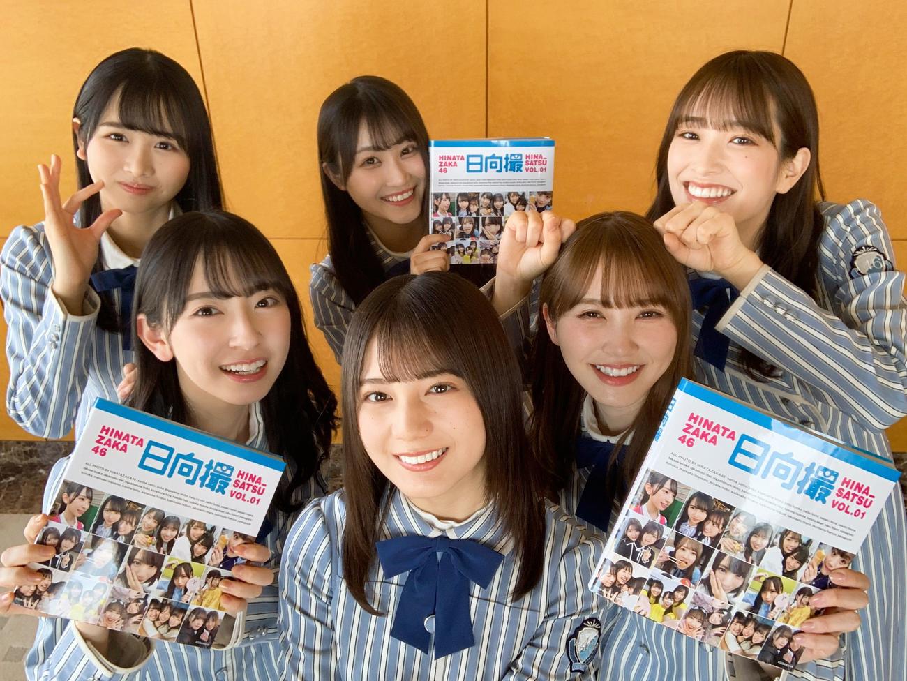 写真集「日向撮」を持って笑顔を見せる日向坂46メンバー。前列左から金村美玖、小坂菜緒、加藤史帆。後列左から上村ひなの、潮紗理菜、佐々木久美