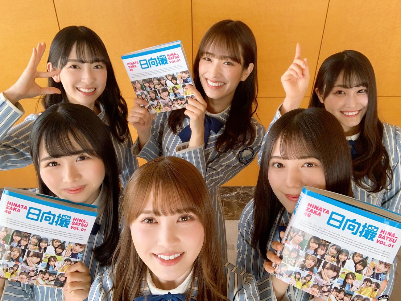 写真集「日向撮」を持って笑顔を見せる日向坂46メンバー。前列左から上村ひなの、加藤史帆、小坂菜緒。後列左から金村美玖、佐々木久美、潮紗理菜