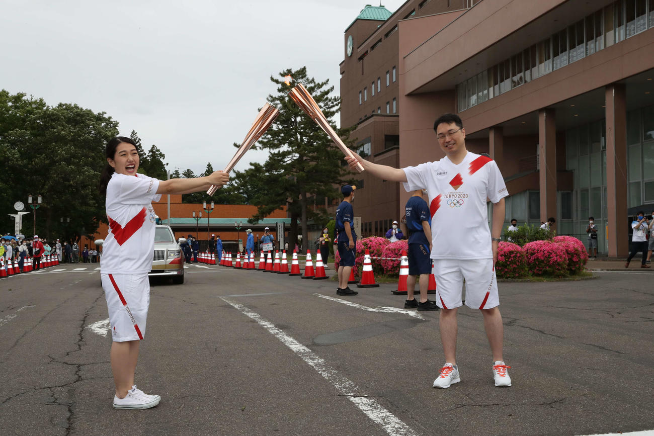 聖火リレー新潟県1日目　聖火ランナーを務めたお笑いタレントの横澤夏子（左）と次走者の建守伸一さん（代表撮影）