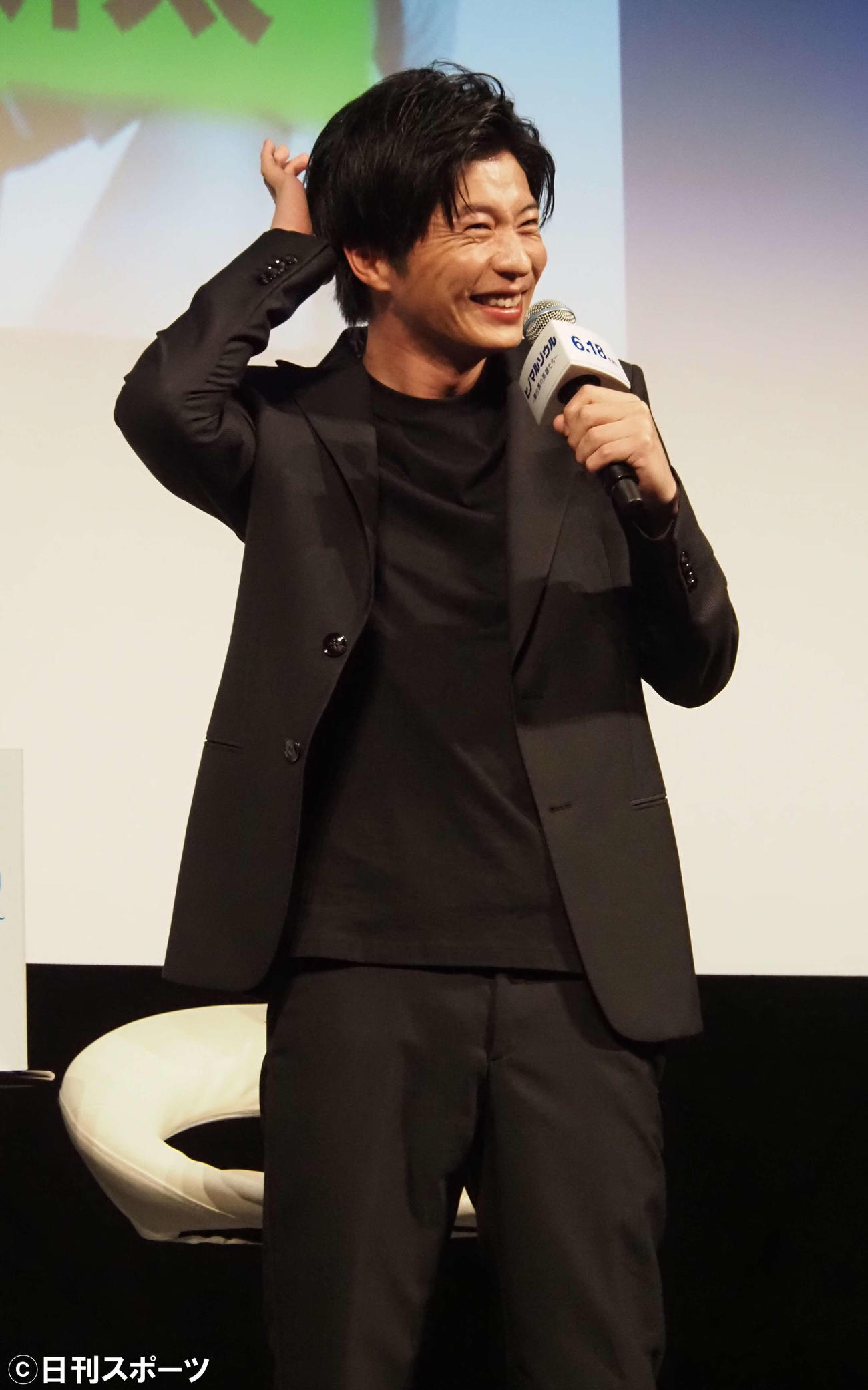 古田新太と電話をつなぎ、笑顔を見せる田中圭（撮影・遠藤尚子）