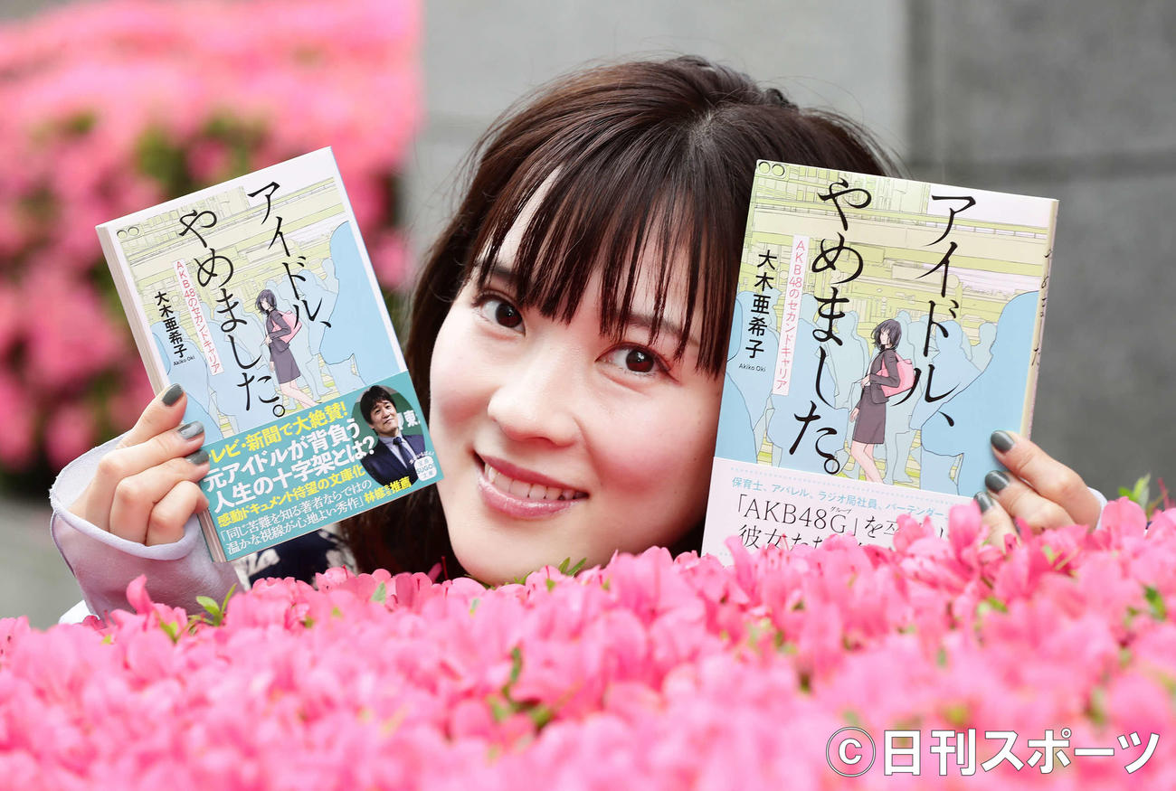著書を手にほほえむ大木亜希子（撮影・丹羽敏通）