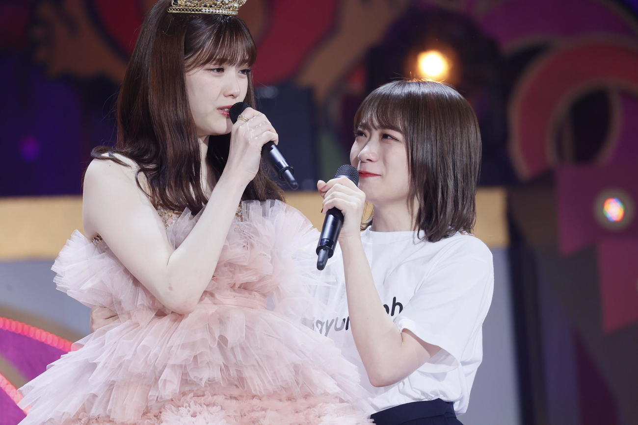 涙ぐんで歌う松村沙友理（左）と秋元真夏