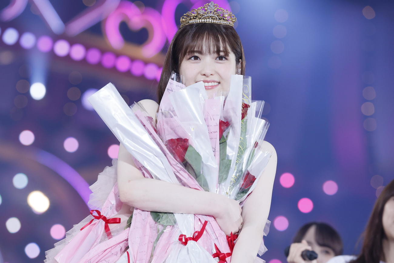 メンバーから渡されたバラの花を抱えて笑顔を見せる松村沙友理