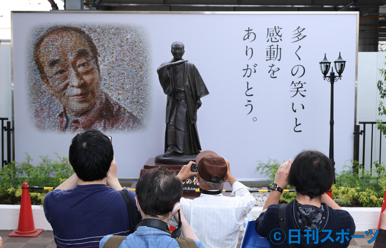 西武新宿線東村山駅東口に作られた志村けんさんの銅像とファンから寄せられた写真によって作られたコラージュの肖像。多くの市民がスマホで撮影していた（撮影・中島郁夫）