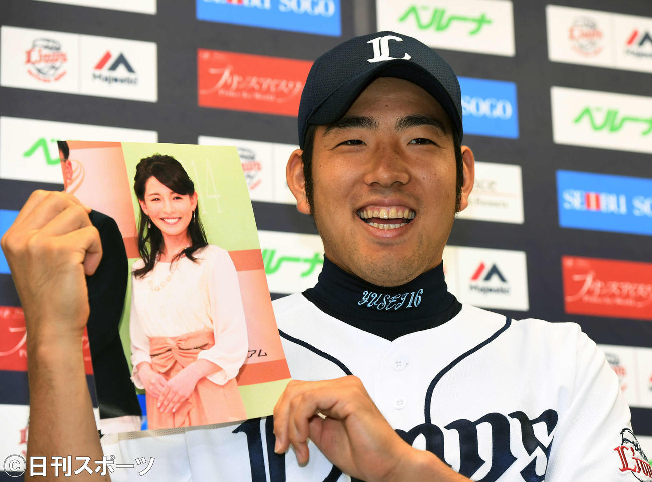 結婚した深津瑠美さんの写真を持ち、笑顔で会見する西武時代の菊池雄星（2016年7月撮影）