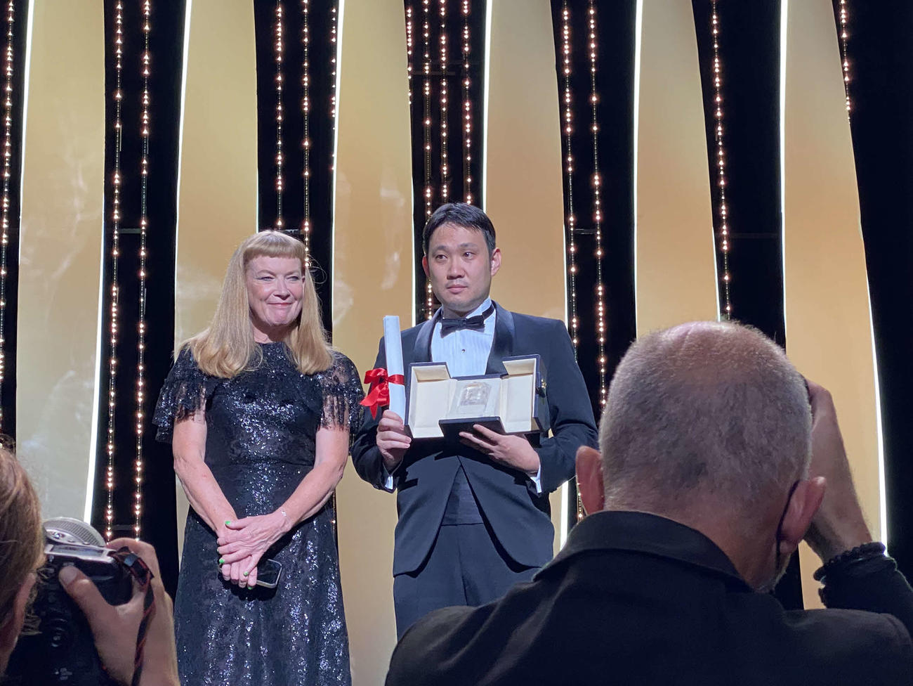 「ドライブ・マイ・カー」でカンヌ映画祭脚本賞を受賞した濱口竜介監督（中央）