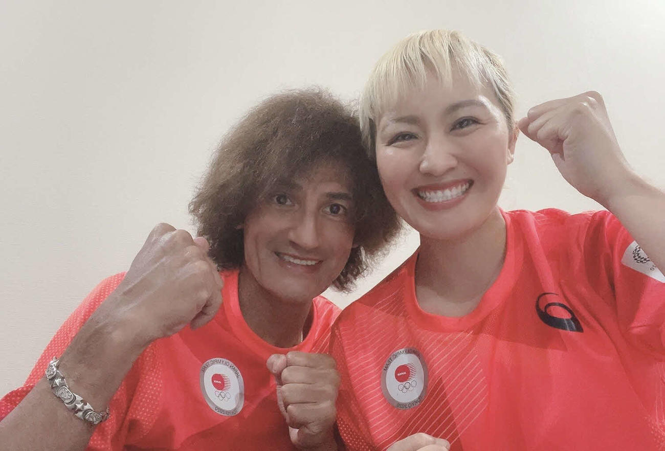 五輪日本代表のユニホームを着用し、ガッツポーズで選手を応援する写真を投稿した本並健治（左）と丸山桂里奈