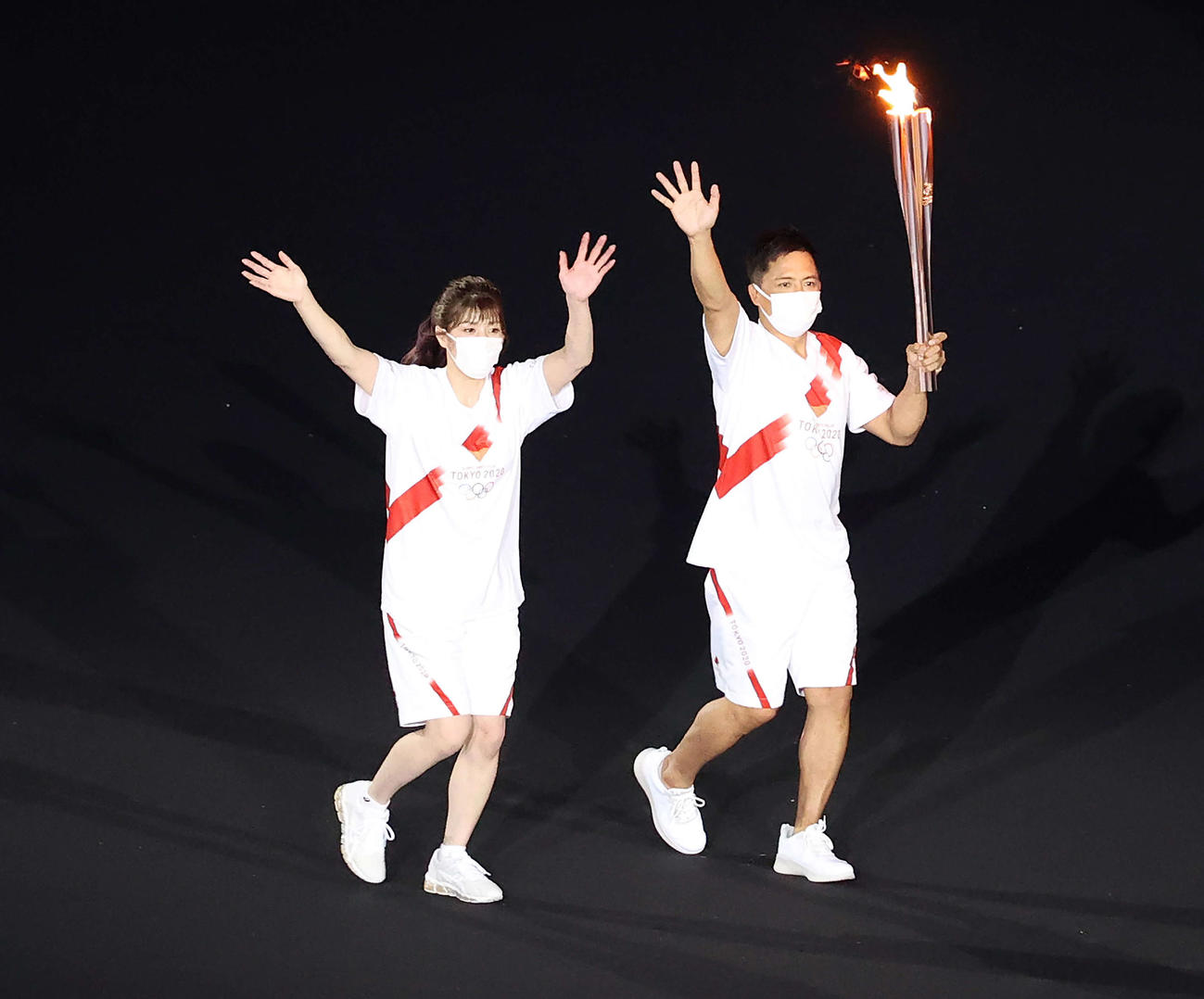 23日、聖火を運ぶ吉田氏（左）と野村氏