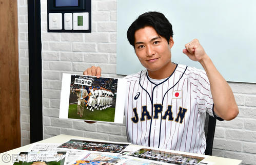 05年の選抜高校野球で入場行進する駒大苫小牧野球部の写真を手に、田中将大に声援を送る劇団EXILEの八木将康（撮影・小沢裕）