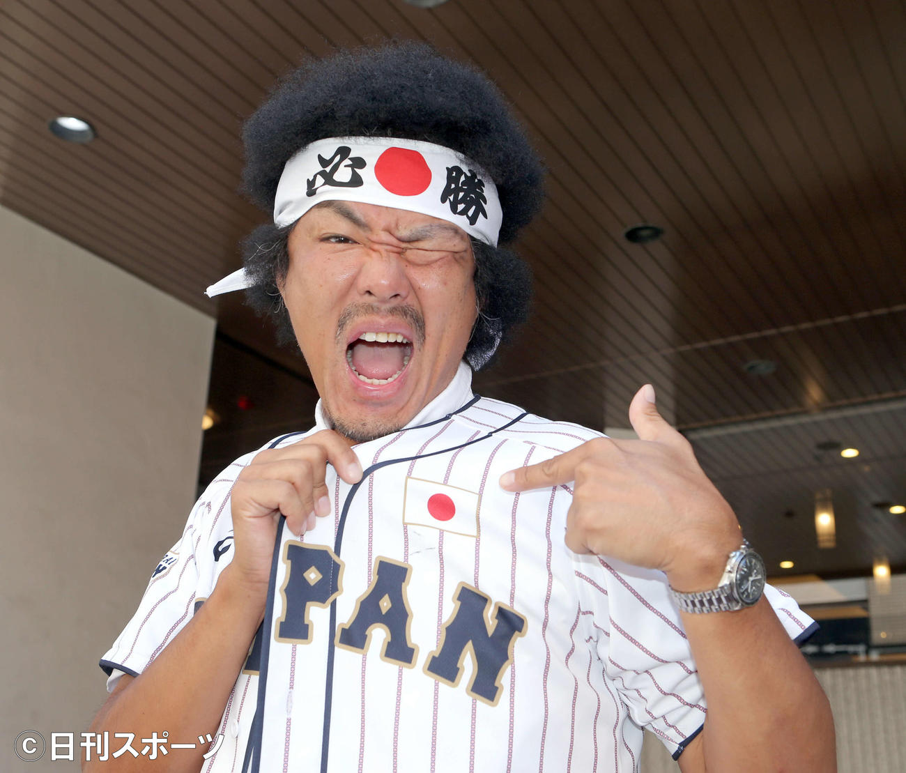 「必勝」の鉢巻きと日本代表のユニホームを身にまといポーズを取るトータルテンボス藤田憲右（撮影・勝部晃多）