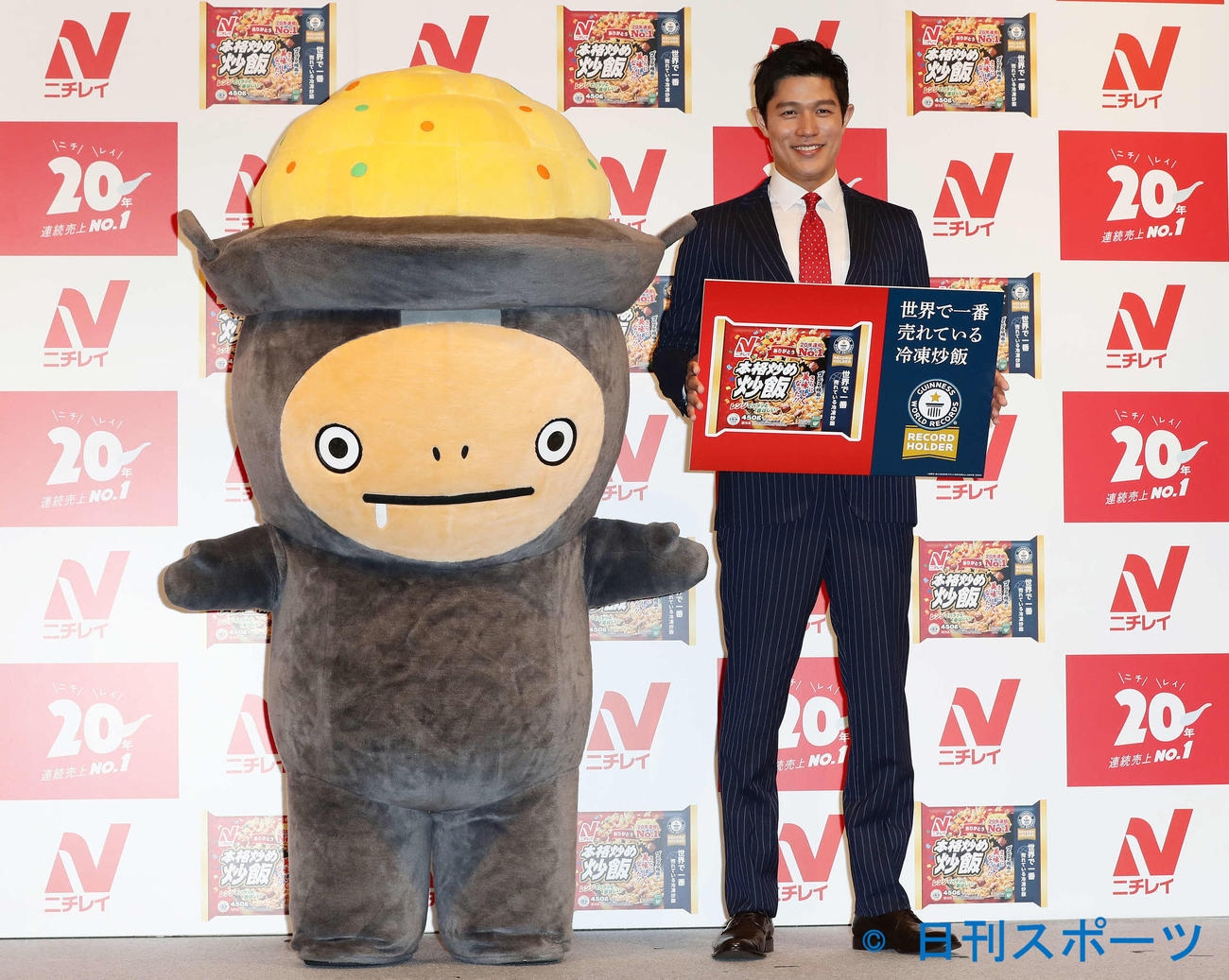 ニチレイ本格炒め炒飯応援キャラクターのイタメくんと写真に納まる鈴木亮平（撮影・丹羽敏通）