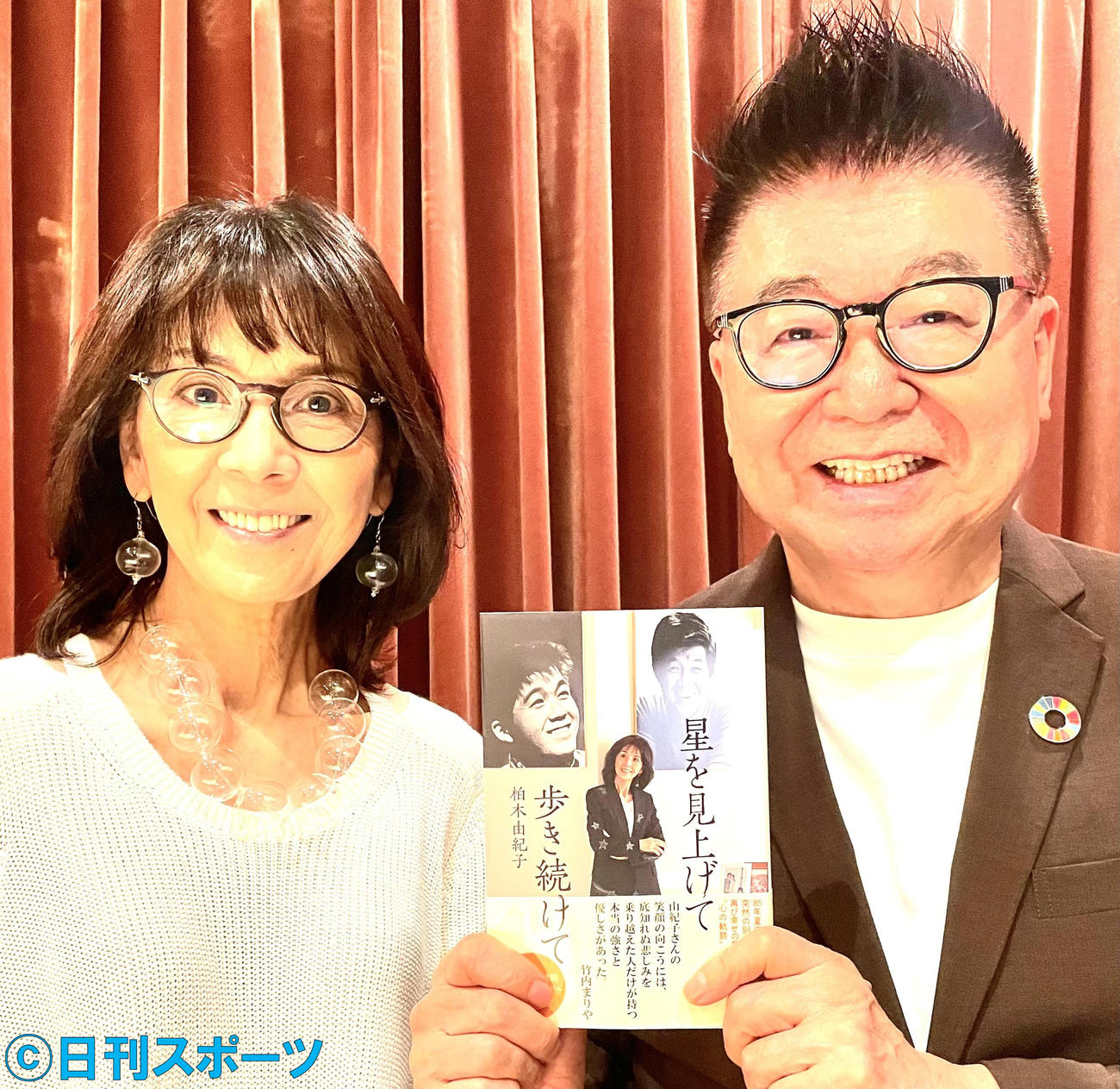 柏木由紀子（左）と、その著書「星を見上げて歩き続けて」を手にする生島ヒロシ