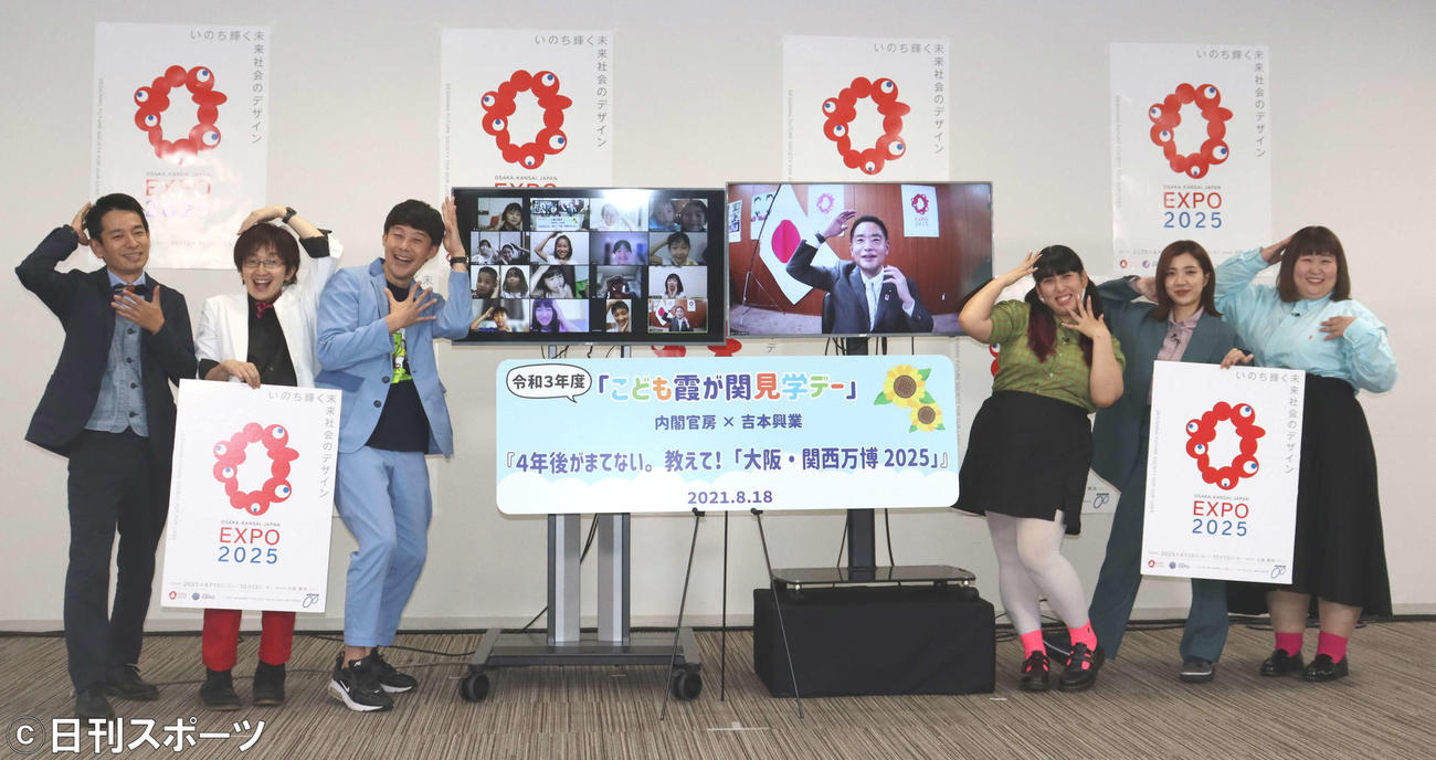 イベントで「アッハーン」ポーズをとる出演者と子どもたち。左からタケト、黒ラブ教授、佐久間一行、井上信治国際博覧会担当大臣、ゆめっち、福田麻貴、かなで（撮影・関根直人）