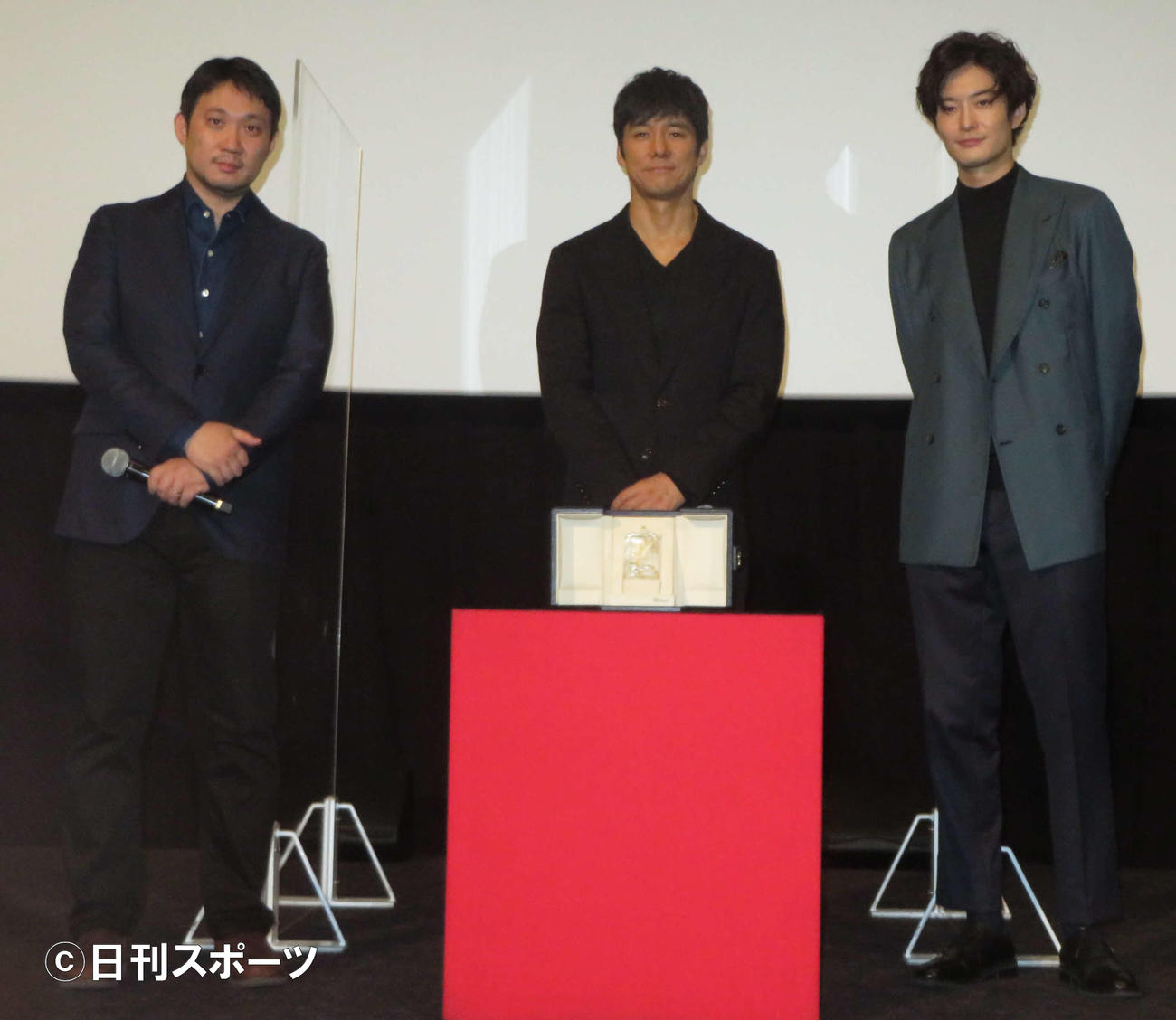 映画「ドライブ・マイ・カー」初日舞台あいさつでカンヌ映画祭脚本賞のトロフィーと記念撮影する、左から濱口竜介監督、西島秀俊、岡田将生（撮影・村上幸将）