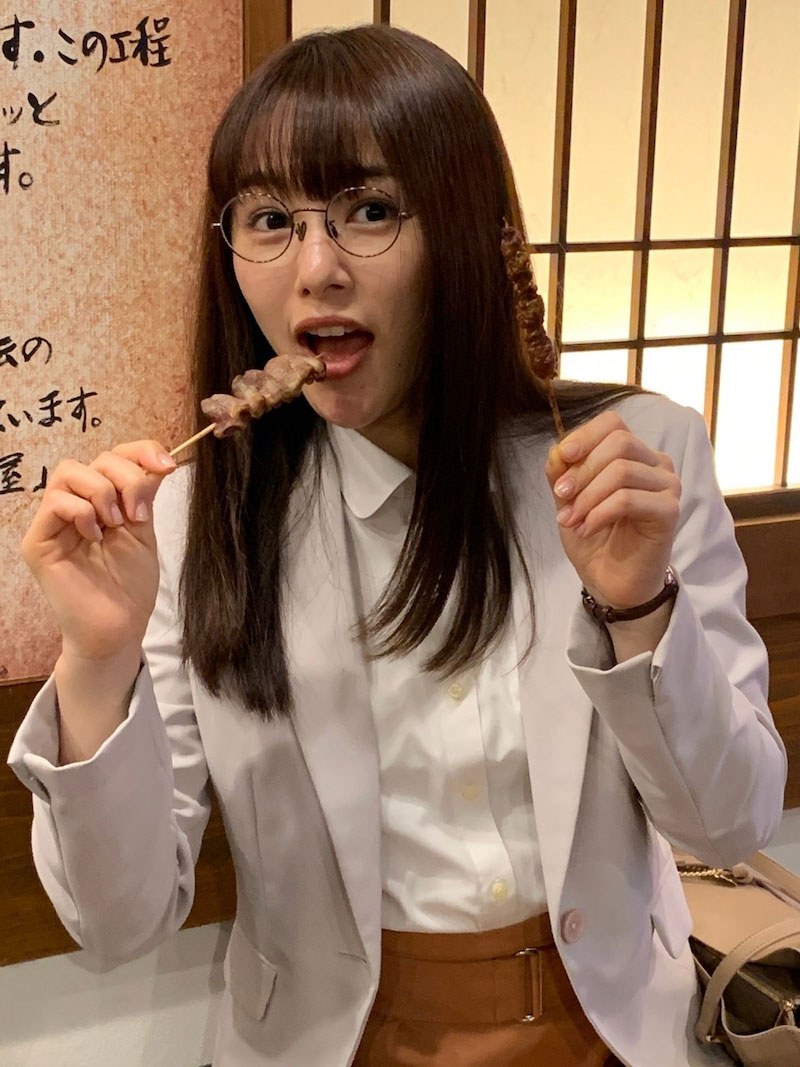 桜井日奈子は両手に持った焼き鳥をぱくり（「ごほうびごはん」オフィシャルブログから）