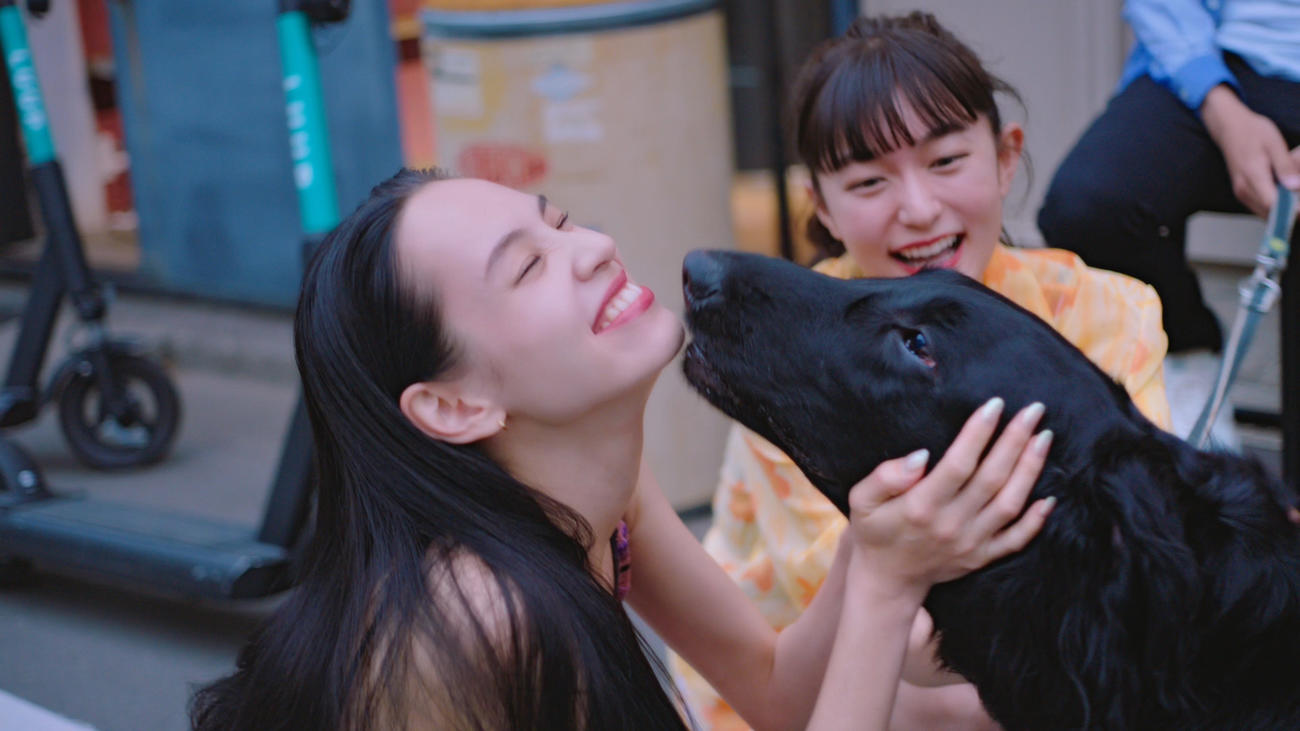 「Tinder」新オンラインCM「キックボード」編で犬と遊ぶ水原希子（左）