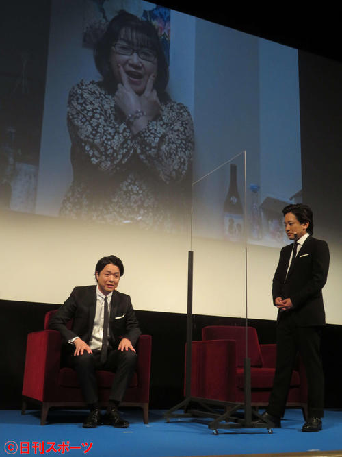 「レミニセンス」公開直前イベントで、音声で登場し、過去を暴露した母の写真がスクリーンに映り、諦めの表情を浮かべる、ぺこぱシュウペイ(左)と見詰める松陰寺太勇(撮影・村上幸将)